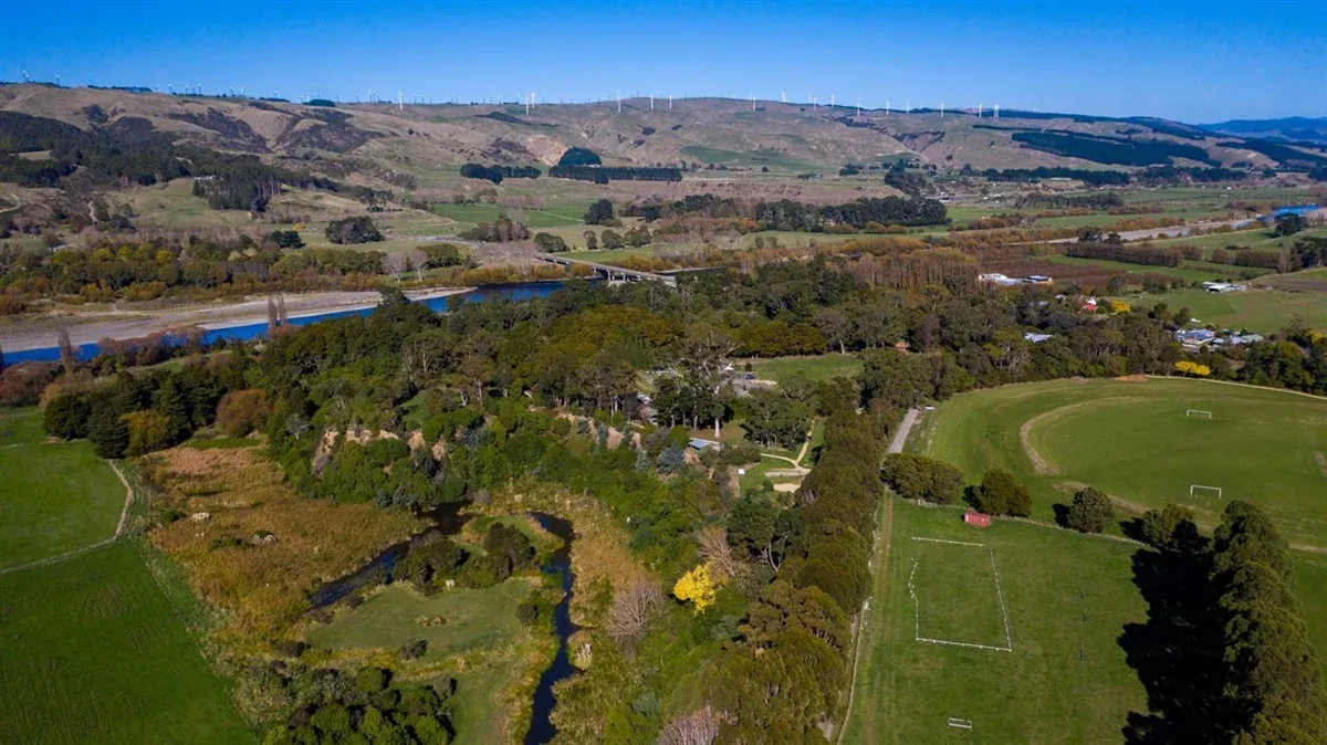 Panoramic view of Ashhurst, showcasing lush greenery and nearby wind farm, a gateway to nature trails