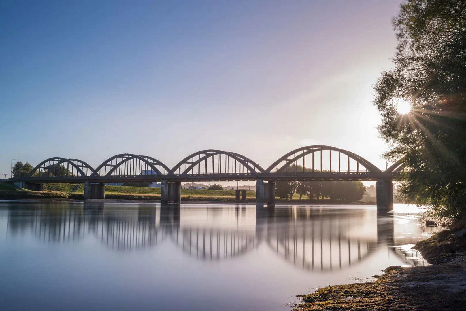 Balclutha Bridge spanning the Clutha River, a historic landmark in a tranquil rural setting.