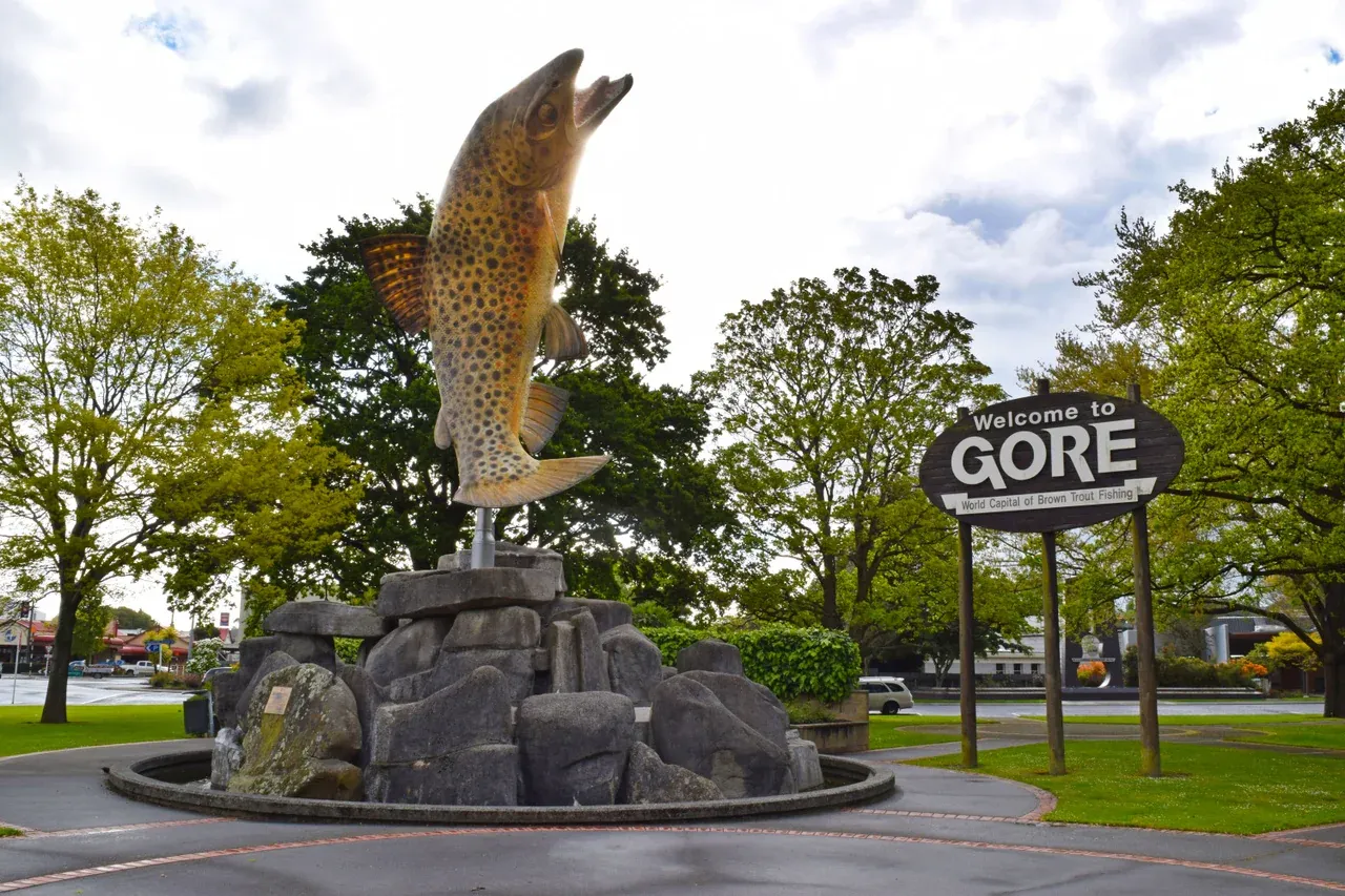 Welcome to Gore sign with iconic brown trout sculpture, celebrating its fishing heritage.