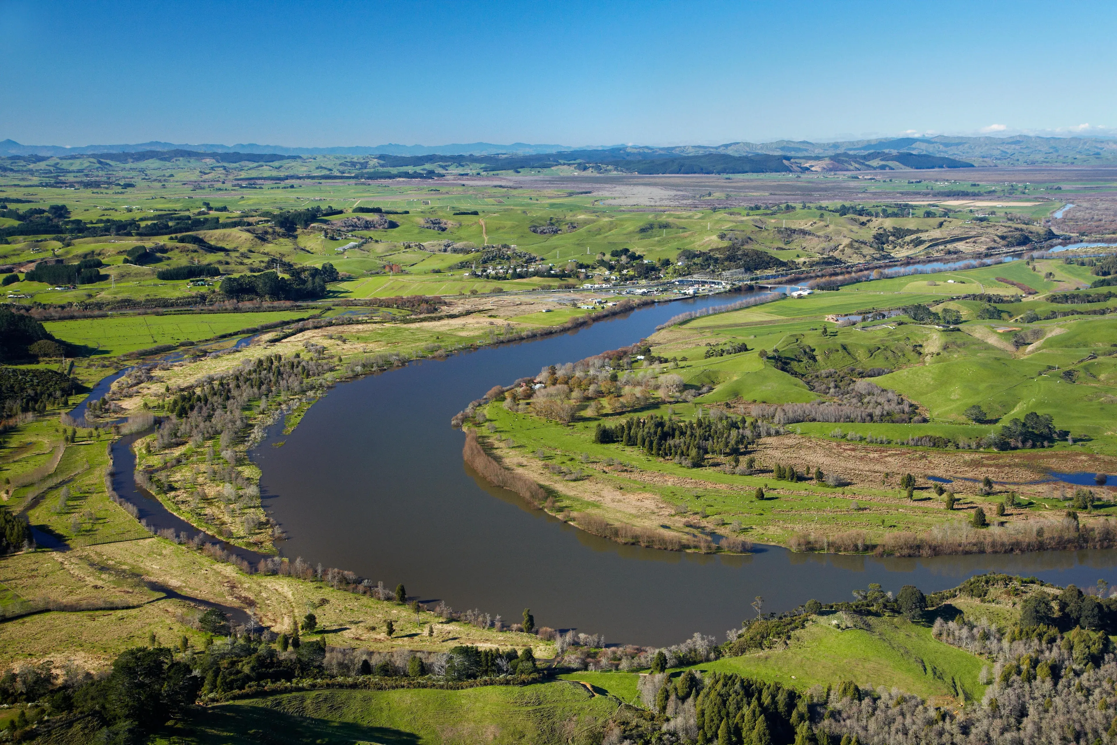 Karaka farmland and serene river landscape, highlighting agricultural and rural business opportunities.