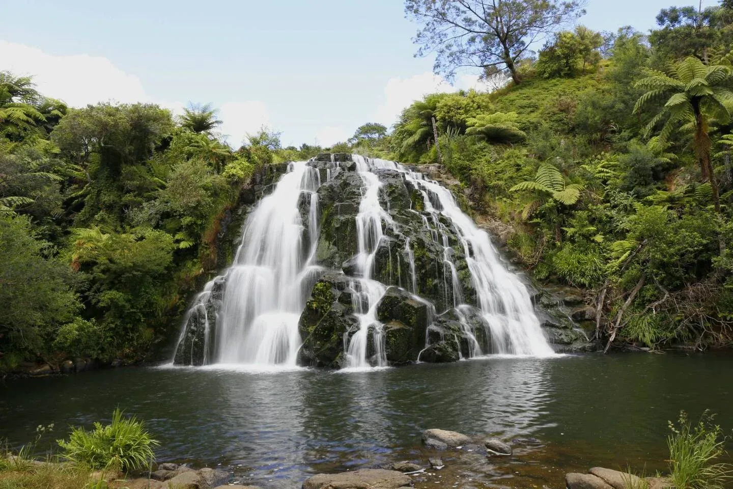 Kerepehi Waterfall surrounded by greenery, highlighting local tourism and natural attractions.