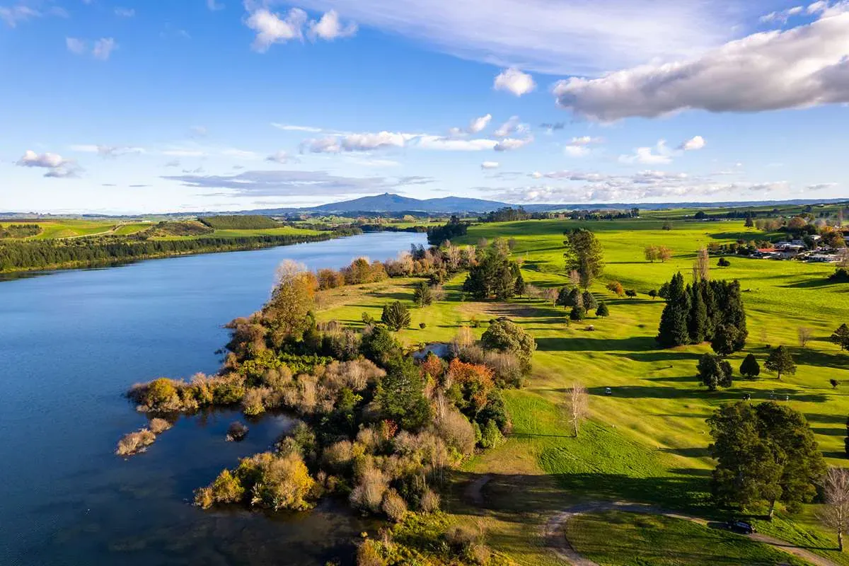 Mangakino lakeside landscape with lush greenery and distant hills, Waikato, New Zealand.