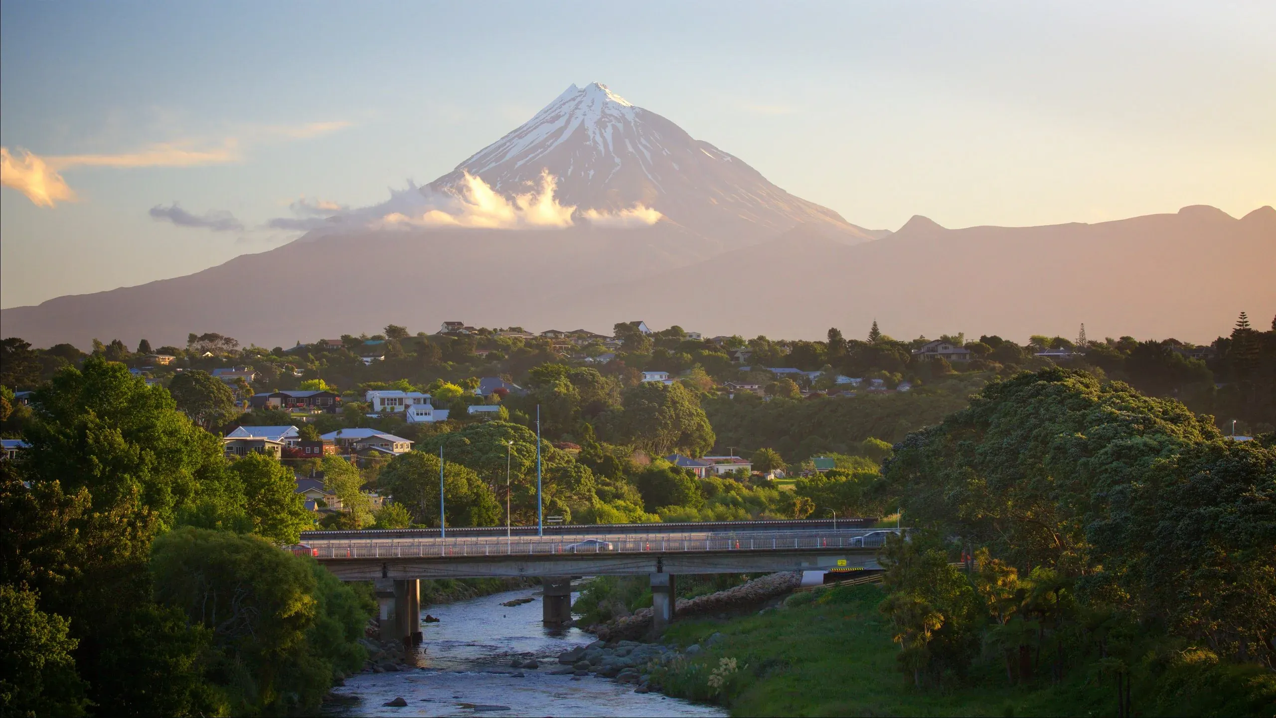 Mount Taranaki overlooking a vibrant townscape and bridge, New Plymouth, New Zealand.